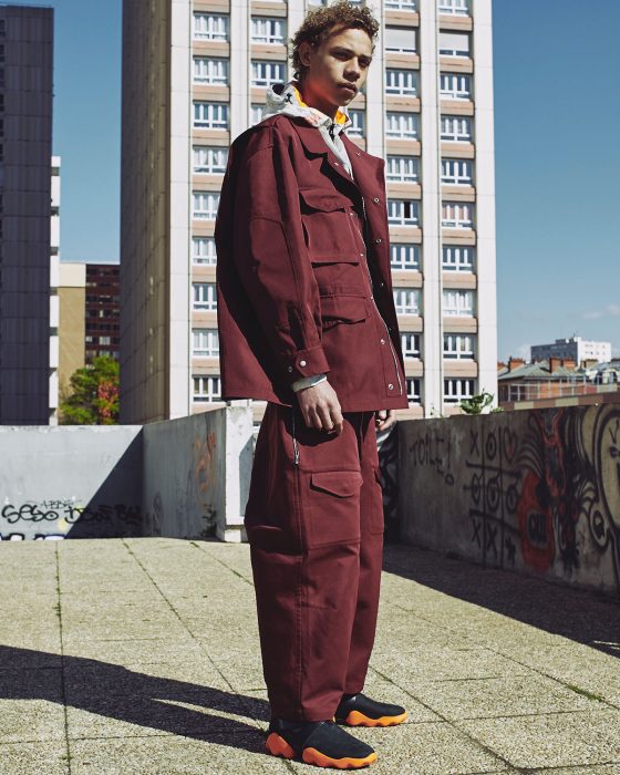 Lye wears jacket Stone Island, t-shirt Kenzo, trousers Hed Mayner.