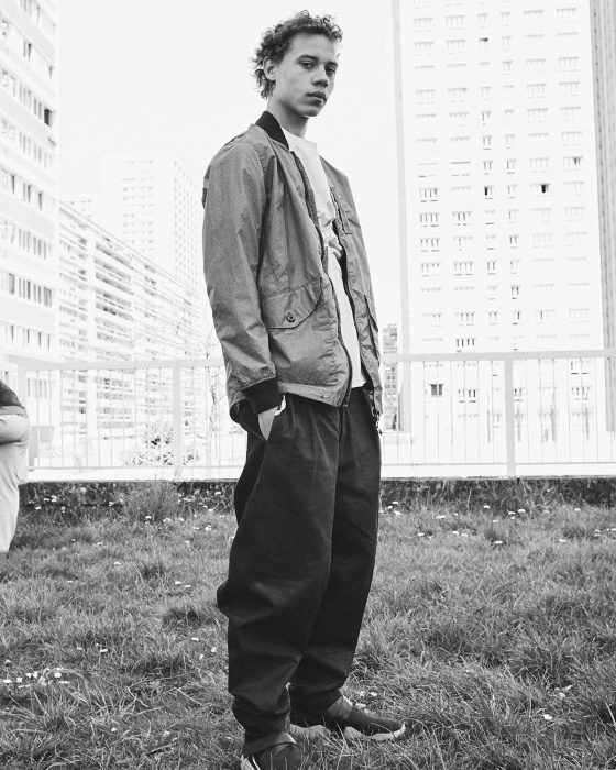 Lye wears jacket Stone Island, t-shirt Kenzo, trousers Hed Mayner.