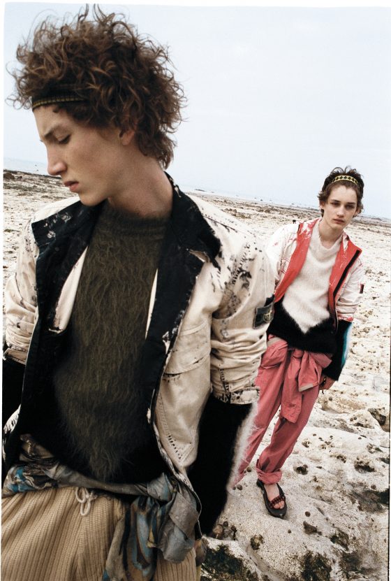 Harold wears jacket by Stone Island, jumper by Louis Vuitton, parka around the waist & shorts by Dries van Noten, headband by Prada. Roberts wears jacket by Stone Island, jumper by Louis Vuitton, jumpsuit by Sacai, headband & sandals by Prada.