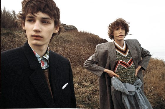 Roberts wears jacket by Balenciaga, shirt & sleeveless pullover by Prada. Harold wears coat by Balenciaga, sleeveless pullover, coat around the waist & trousers by Prada.