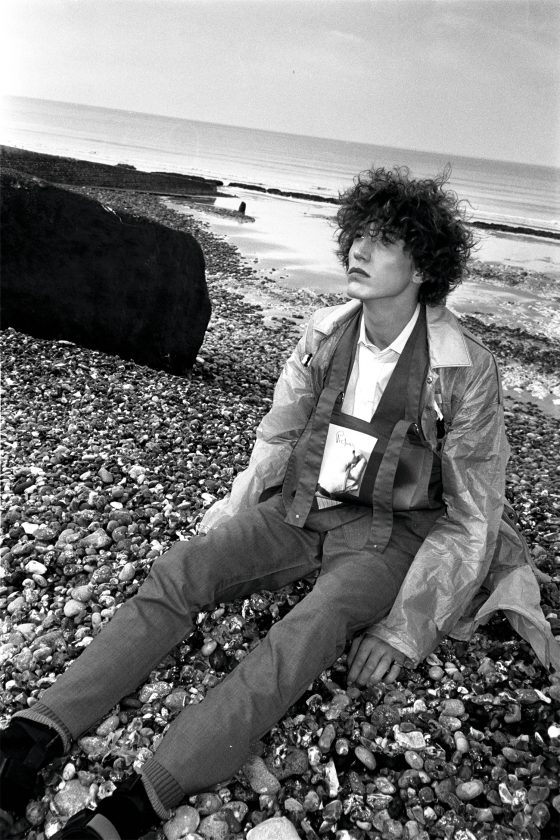 Coat, suit, socks & sandals by Prada, shirt by Balenciaga, cropped apron top by Raf Simons x Robert Mapplethorpe.